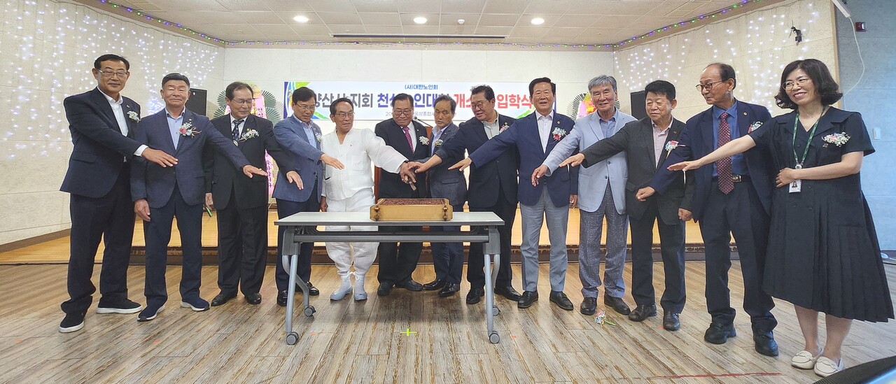 양산시지회 동부양산 천성노인대학 개소식에서 서춘계 지회장(왼쪽에서 여섯 번째)이 내빈들이 떡케이크를 자르고 있다. 