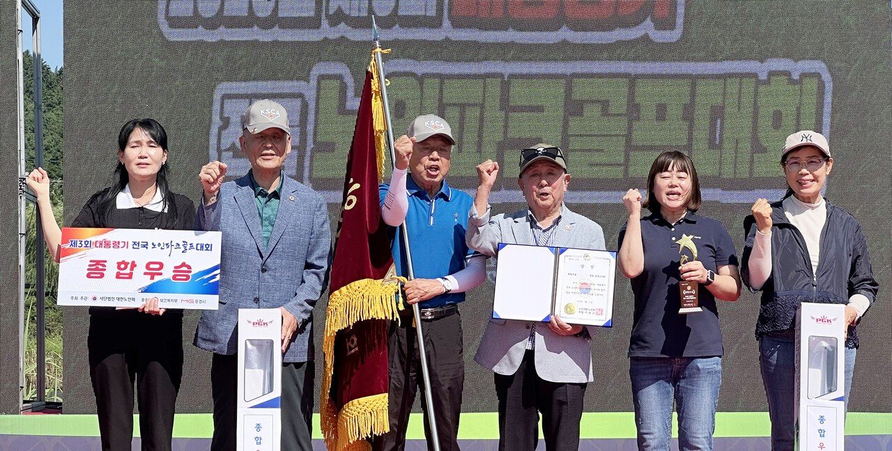 종합우승을 차지한 문경시지회 박경규 지회장(왼쪽에서 세 번째)이 우승기를 들고 선수 및 직원들과 기념촬영을 하고 있다. 왼쪽 두 번째는 시상을 한 최재덕 중앙회 상임부회장.  