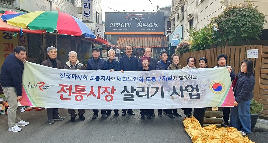 도봉구지회가 신창시장에서 전통시장 살리기 사업 기념촬영을 하고 있다. 왼쪽 다섯번째 정승기 지사장, 여섯번째 뒷줄에 심형섭 지회장. 